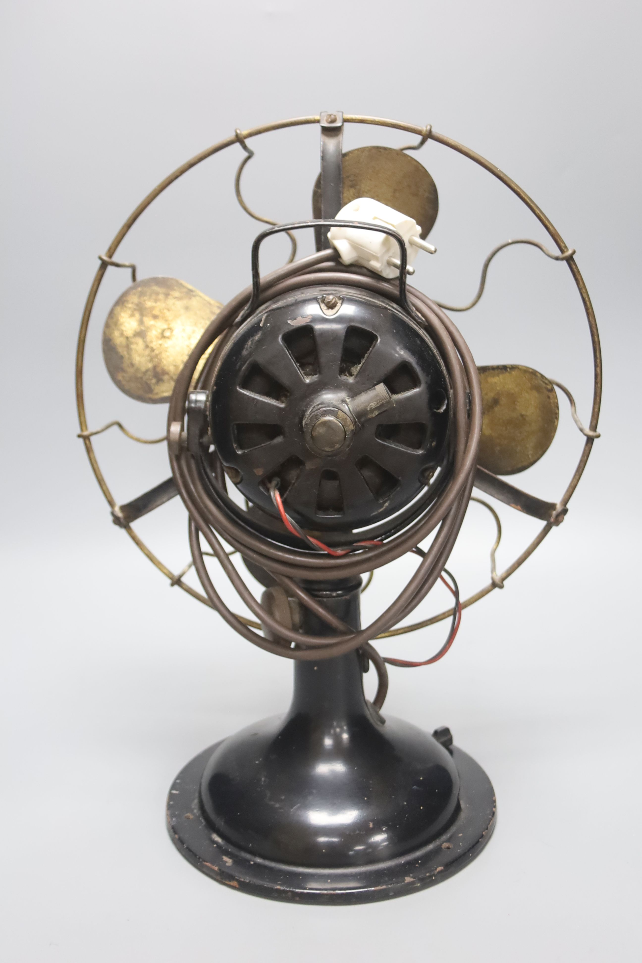 A vintage cast iron and brass propeller desk fan, height 42cm